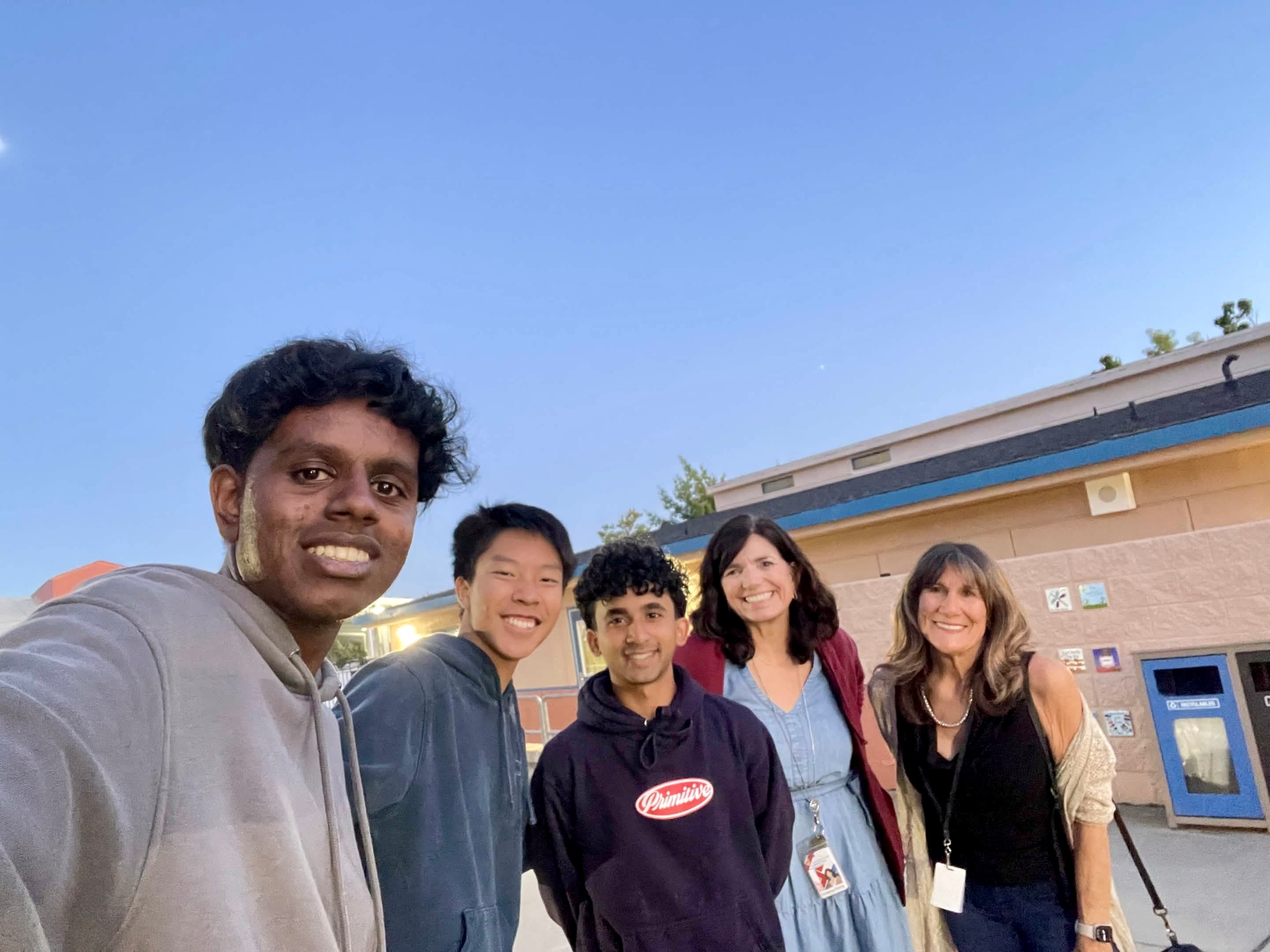Pillars volunteers and adult partners smiling together outside Family Science Night.