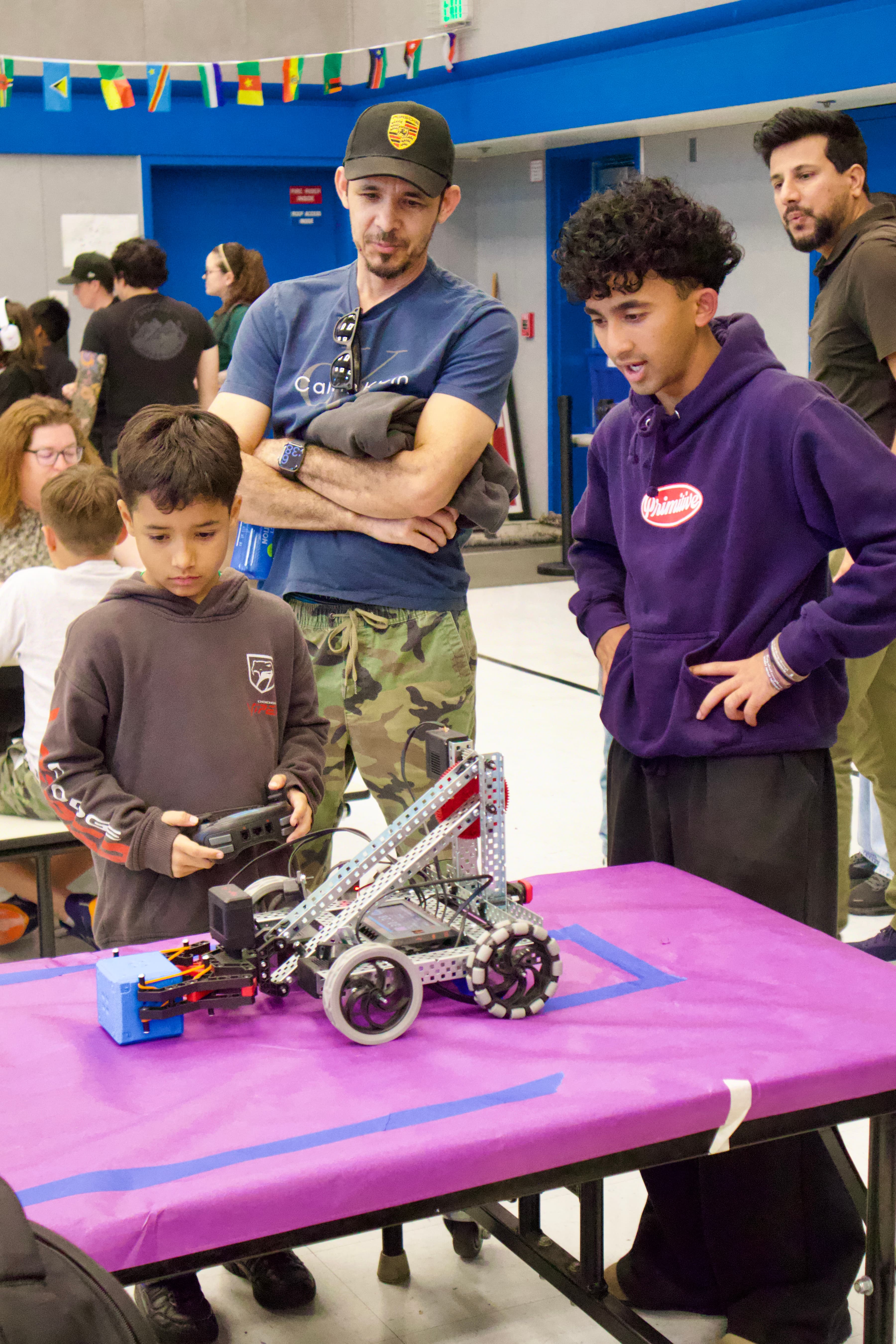 A mentor and younger participant operate a robot together.