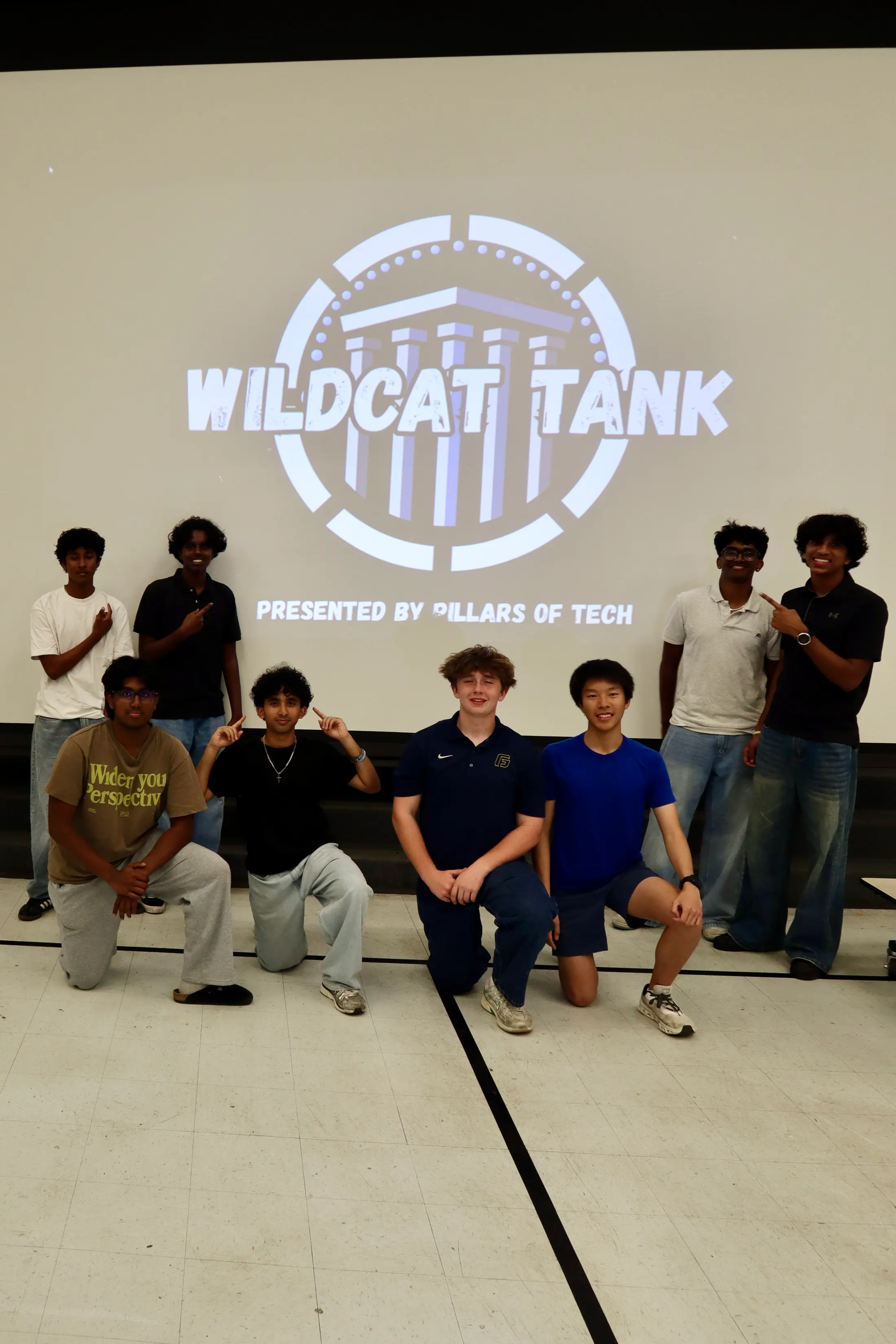 The Pillars team gathers in front of the Wildcat Tank presentation screen.